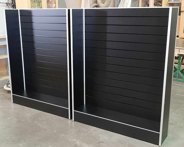 2 free standing Plankwall black slatwall panel display wall stands with side walls in a factory setting