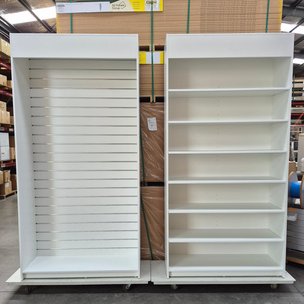Two Plankwall tall display cabinets, one with shelves, the other with slatwall in a factory setting
