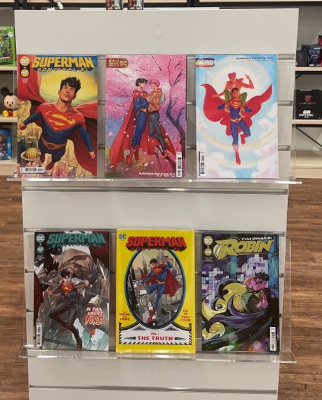 Comin books dipslayed on 600mm acrylic book display shelves mounted on slatwall in a book store