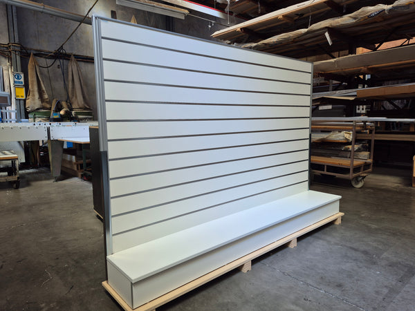 Plankwall free standing display wall panel - bespoke double width slatwall  in white shown in a factory setting