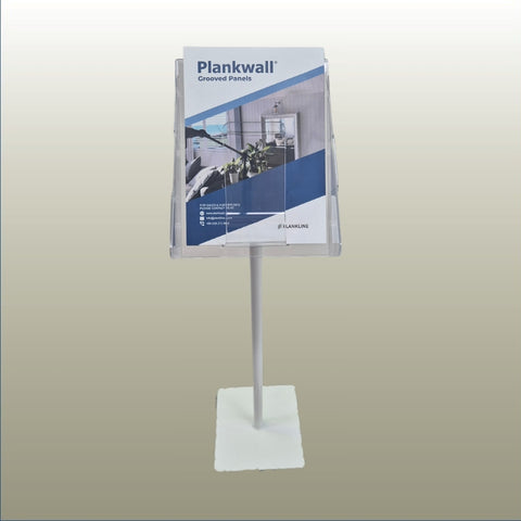 A clear acrylic freestanding sign holder on a white metal stand with a square base, holding a Plankwall product brochure against a neutral gradient background.