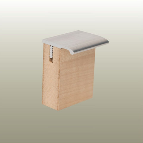 A sample of an aluminium Stickman Drawerpull profile in a light wood MDF panels on a gold background 