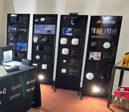 four Two-sided slatwall display panels in all black used to display lighting samples and information from Steinel - all panels are free standing on metal feet