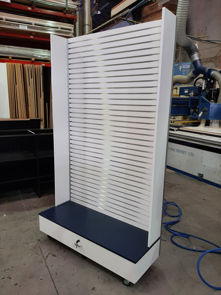 Plankwall Free standing slatwall display wall panel with side walls and black base with lockable drawer shown in factory setting