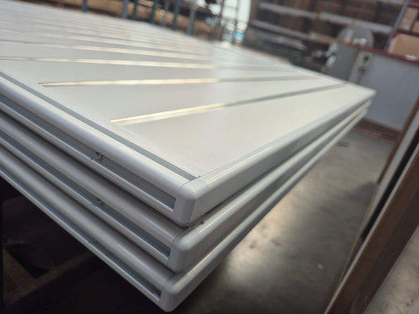 Stack of white Plankwall slatwall panels with attached G18 Gondola Post extrusions for edge capping MDF 18mm gondola panels powder coated white