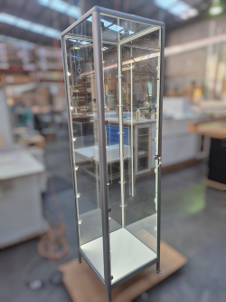 Tall mirrored display cabinet in a room with blurred background