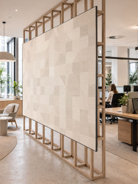 A large modern office partition screen with a light beige wood-grain patterned panel caped with black MCLN aluminium capping profiles in a natural wood frame, shown in a bright, contemporary office space.