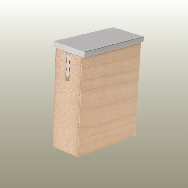 Close up of a Stickman aluminium MCLNCAP capping profile section inserted in a 18 mm MDF panel on a gold background