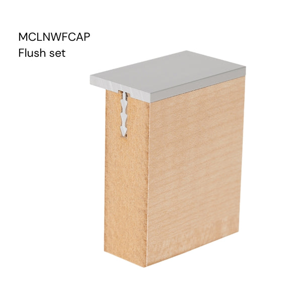 Close up of a Stickman aluminium MCLNWFCAP wall fix capping profile flush set section inserted in a 18 mm MDF panel on a white background labelled