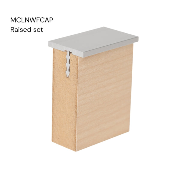 Close up of a Stickman aluminium MCLNWFCAP wall fix capping profile raised set section inserted in a 18 mm MDF panel on a white background labelled