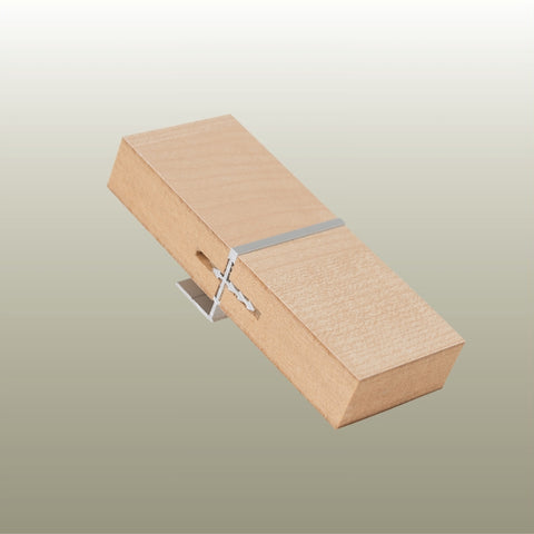 A close up of a Stickman Linear MCLNWFJOIN sample - a aluminium butt join profile in flush set with wall fix in light wood MDF panels on a gold background