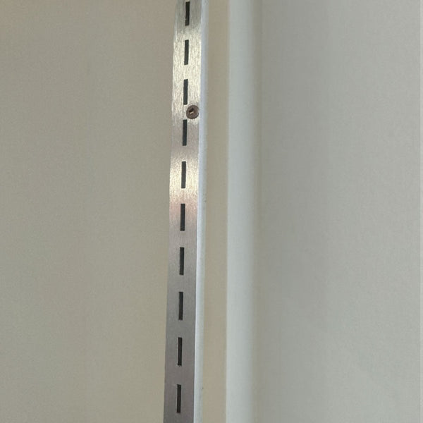 slotted wall channel in aluminium mill finish supports metal shelving for retail displays