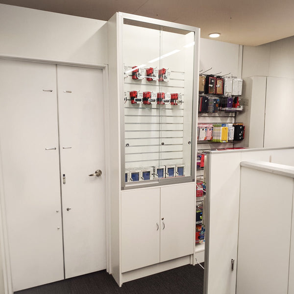 Custom designed retail display glass cabinet with slatwall feature and lockable cabinet shown in store