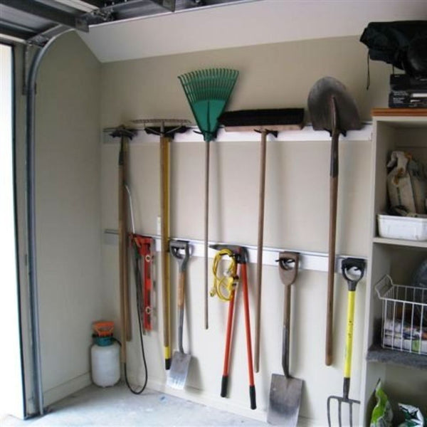 Plankwall garage organization system with tools hanging on a wall-mounted implement bracket rack.