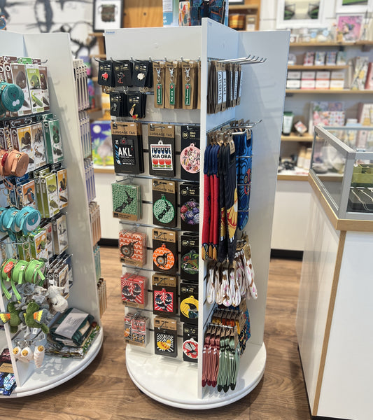 A Plankwall freestanding four-sided display unit with slatwall panels on all sides displaying retail items in a store