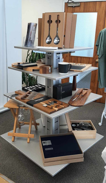 Display of kitchen utensils and appliances on a Plankwall  5 tier display unit in a room with large windows.