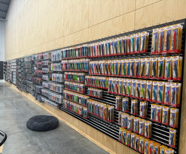 Black 50mm slatwall panels lining walls with prongs displaying various items in a store setting