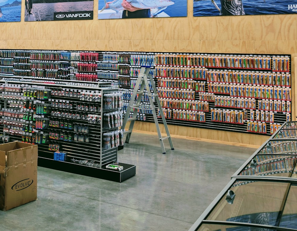 Fishing store interior with Plankwall black 50mm slatwall panels and Monster Fishing branding on the wall.