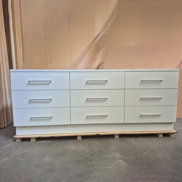 Plankwall white cupboard unit with 9 drawers in a factory setting