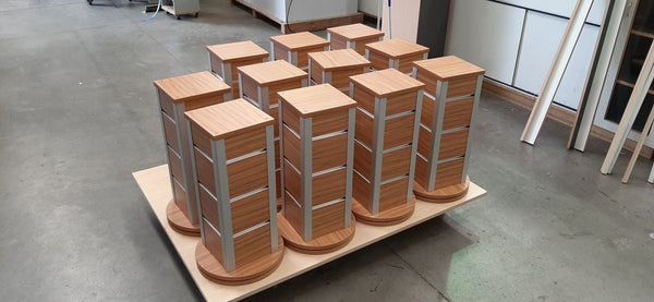 Plankwall Counter Top Retail Display stands with slatwall grooves in a wood finish on a pallet in a factory setting