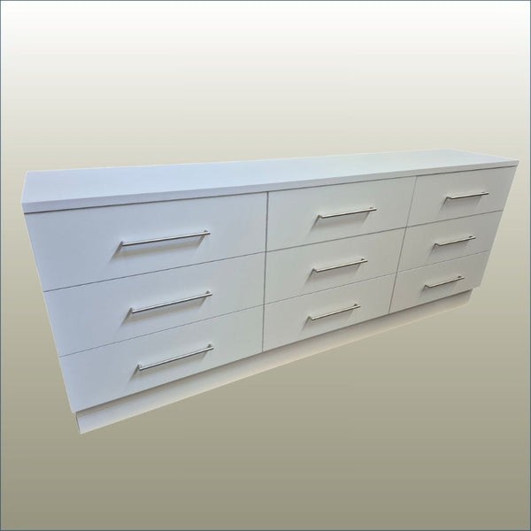 Plankwall white cupboard unit with 9 drawers on a gold background