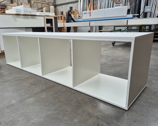 Plankwall white display shelf bench with four open storage cubes in a factory setting