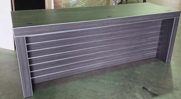 picture of a retial display table with cable ports on top and slatwall display space on the front in a dark wood finish