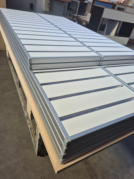 Plankwall EP18 aluminium capping shown capping white 18mm slatwall mdf panels in a factory 