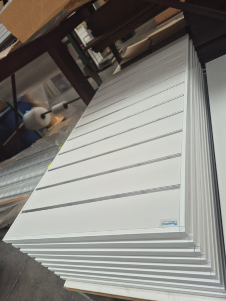Stack of Plankwall 18mm slatwall panels edged with EP18 aluminium panel capping powder coated in white