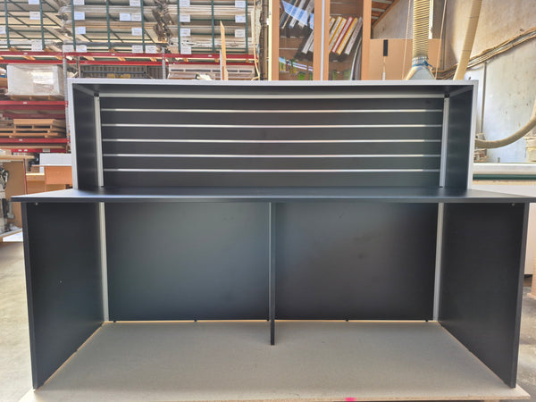 A Plankwall Reception Desk, 1800mm wide in Black shown front one in a factory setting