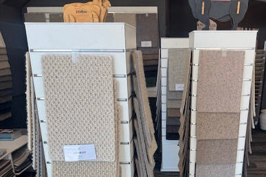 Collection of various rug samples displayed on a slatwall stand fastened in place with PC3 acrylic clips