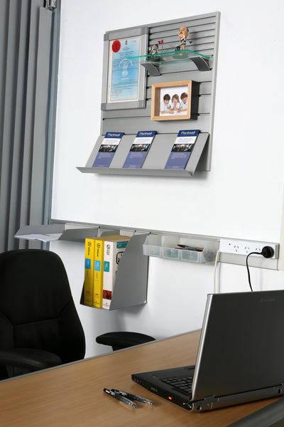 Modern office setup with a desk, laptop, chair, featuring a Plankwall Utility Plank wall-mounted storage system for tight and small spaces.