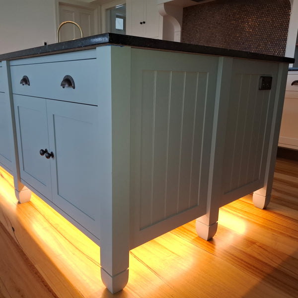 Close up of Plankwall W Groove used in side panels in a kitchen island lit up from below