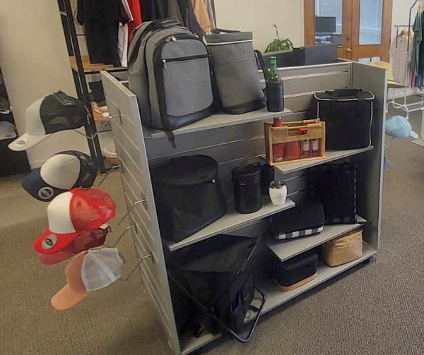 an image of promotional items merchandised on grey shelves on a  Grey display gondola in a retail showroom.