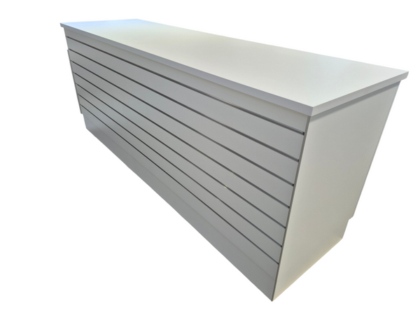 The front of a Plankwall retail counter with slatwall for product displays in white on a white background