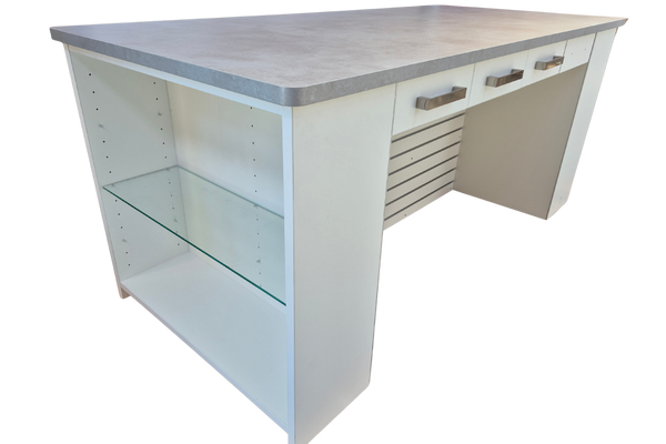 Plankwall retail counter in white with a stone top, glass shelf on the side, drawers int eh back and slatwall hanging space underneath on a white background.