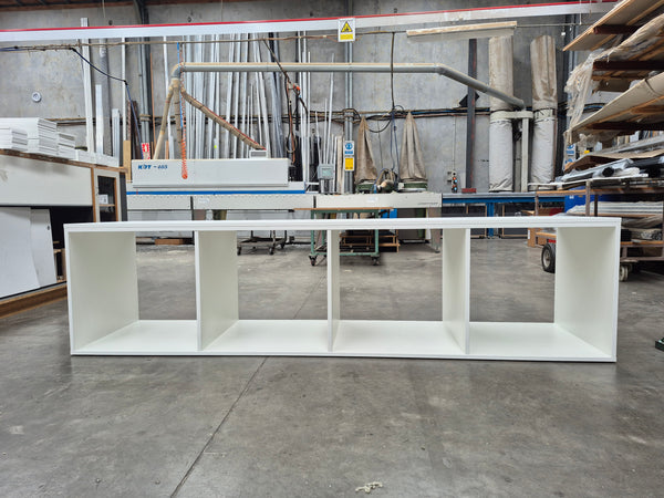 Plankwall white display shelving unit  with four open storage cubes in a factory setting