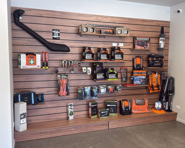 Plankwall wood finish slatwall wall display panel with Plankwall panel shelf base displaying health & Safety items in a showroom setting.