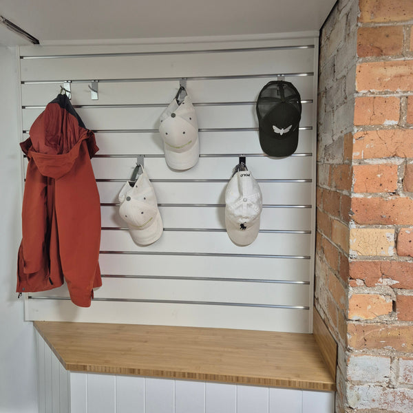 Plankwall Single Prongs used to hand caps and jackets in garage on a Plankwall slatwall panel.