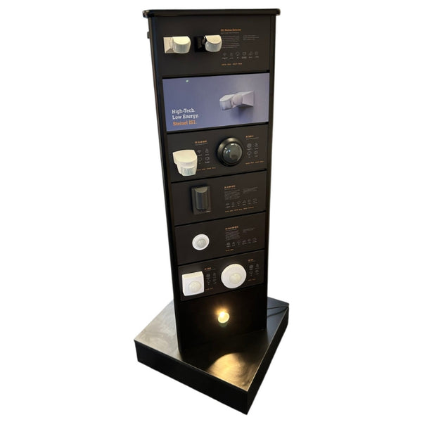 Plankwall 3-sided rotating floor display stand in custom black with light fixtures in a showroom cut out image