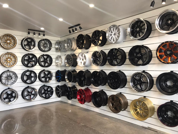 Display of various car wheels on Plankwall 150mm slatwall panels in a showroom.