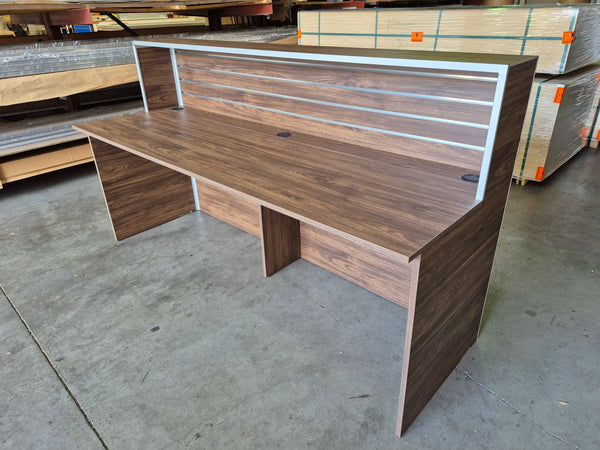 Plankwall wooden Reception Desk in walnut shown in a factory setting