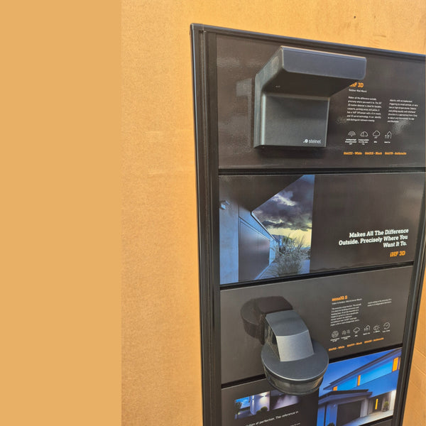 Close up of a Plankwall free-standing two sided display panel made from black slatwall showing product details