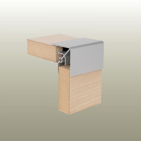 Close up of a Stickman sample of a RA18 square head aluminium corner profile joining two non mitred light wood MDF panels on a gold background