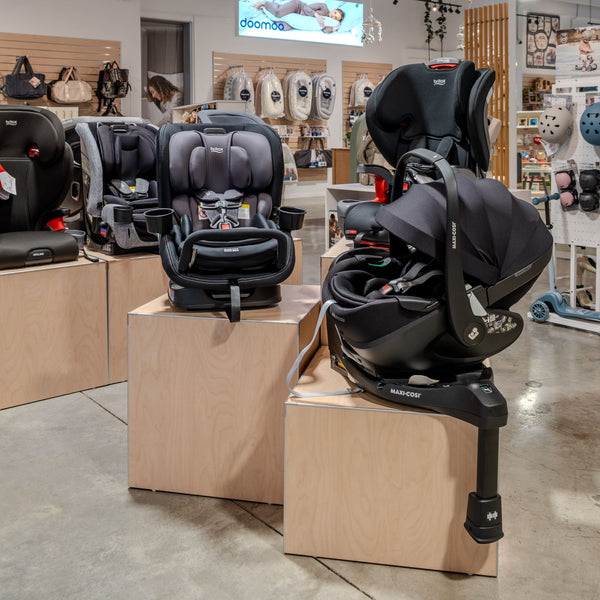 Baby car seats on display plinths  in a store with wooden blocks