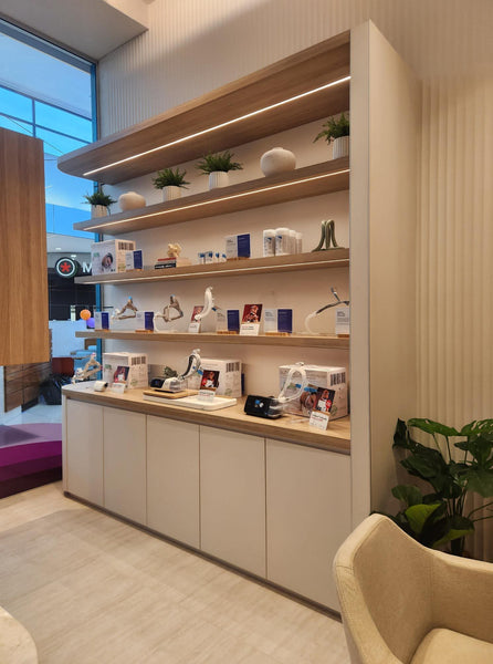 Stickman NC18 aluminum corner joinery profile featured in retail  cabinetry as part of a modern retail interior with wooden shelves and cabinets, featuring decorative items and plants.