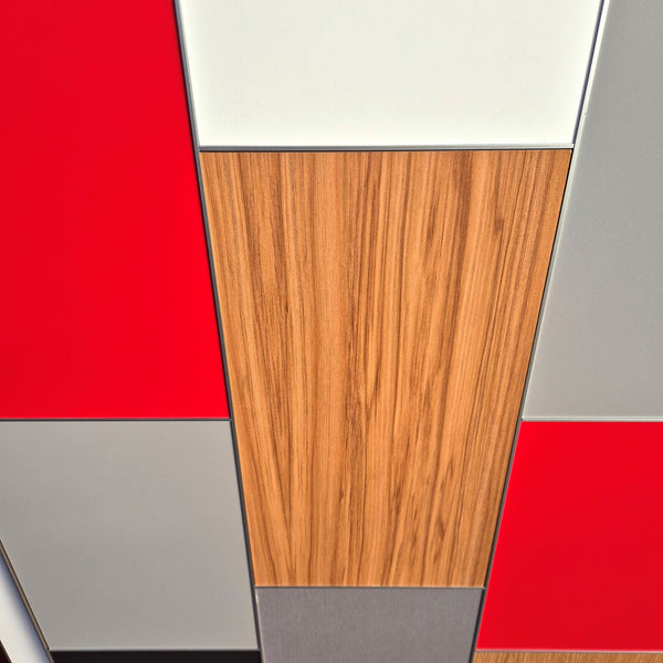 Modern geometric wall panels with a mix of solid red, white, gray, black, and wood grain textures joined by Stickman Linear Wall Fix butt join profiles MCLNWFJOIN