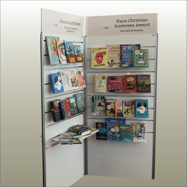 Plankwall three panel Radial display stand with various books on a white stand against a gold background