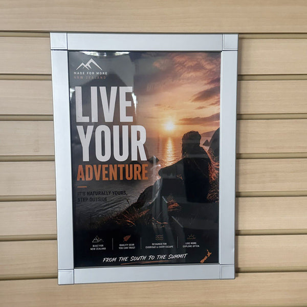 Framed A3 postaframe with 'Live Your Adventure' text on a wooden  slatwall