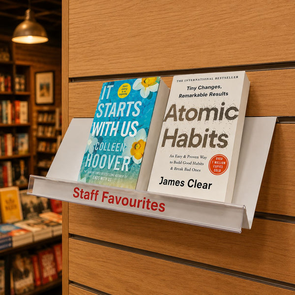 Two books, 'It Starts with Us' and 'Atomic Habits', on a staff favourites display in a bookstore.